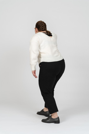 Vista posteriore di una donna grassoccia in abiti casual in cerca di qualcuno