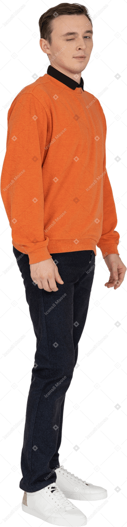 Junger mann im orangefarbenen sweatshirt stehend