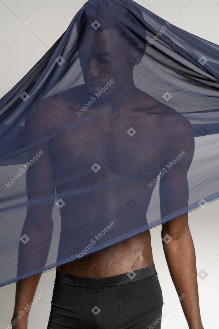 Vorderansicht eines jungen afro-mannes, der mit einem dunkelblauen schal bedeckt ist