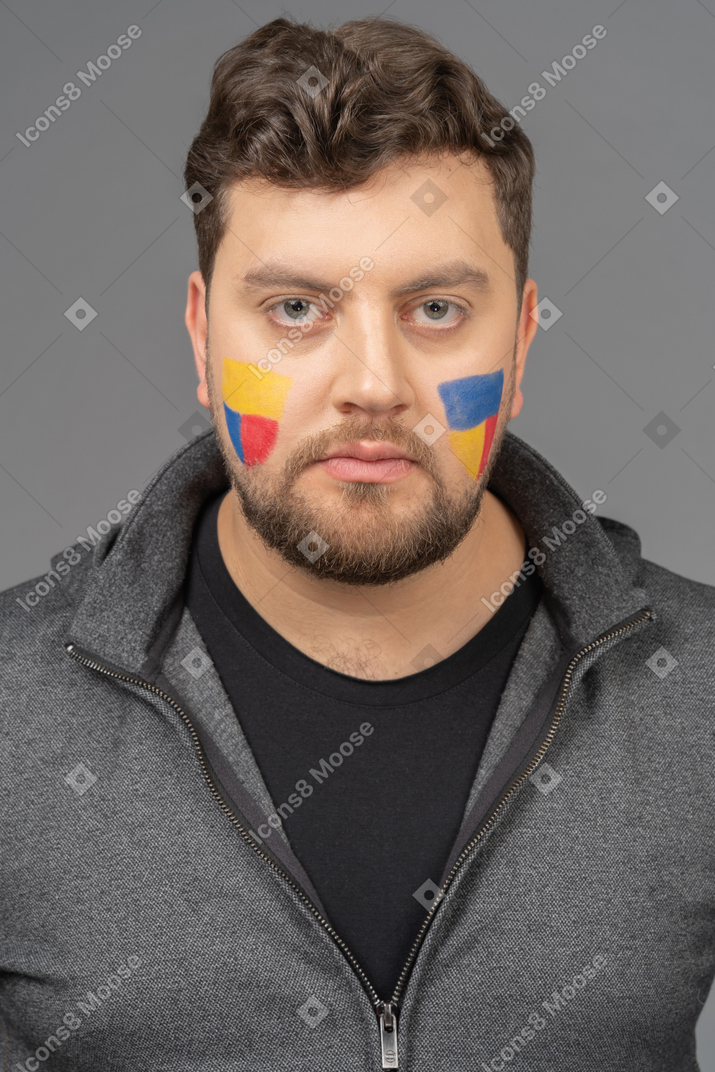 Front view of a male football fan with colorful face art