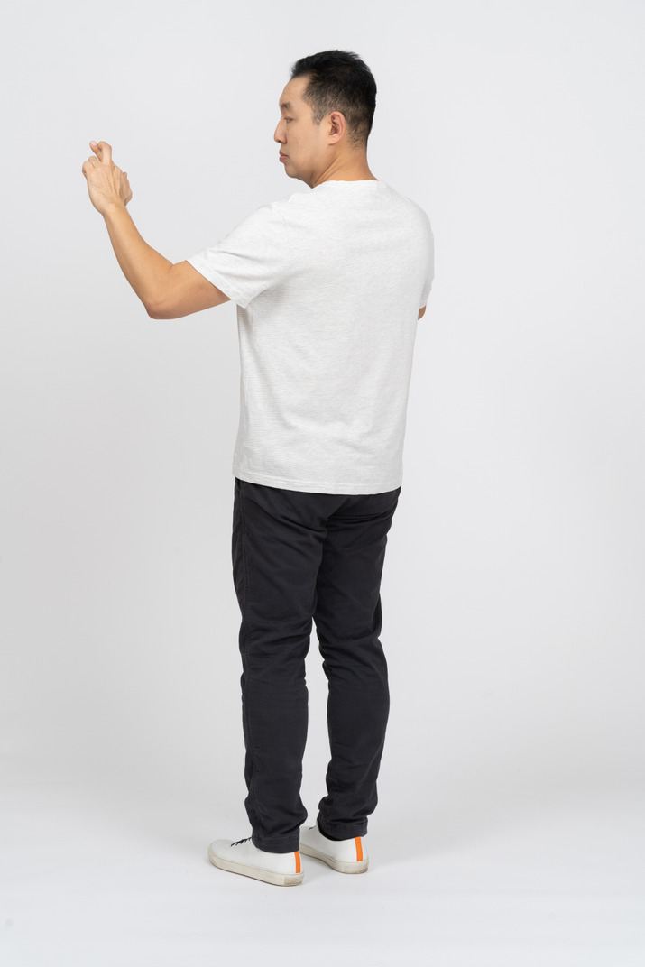 Three-quarter view of a man in casual clothes crossing fingers