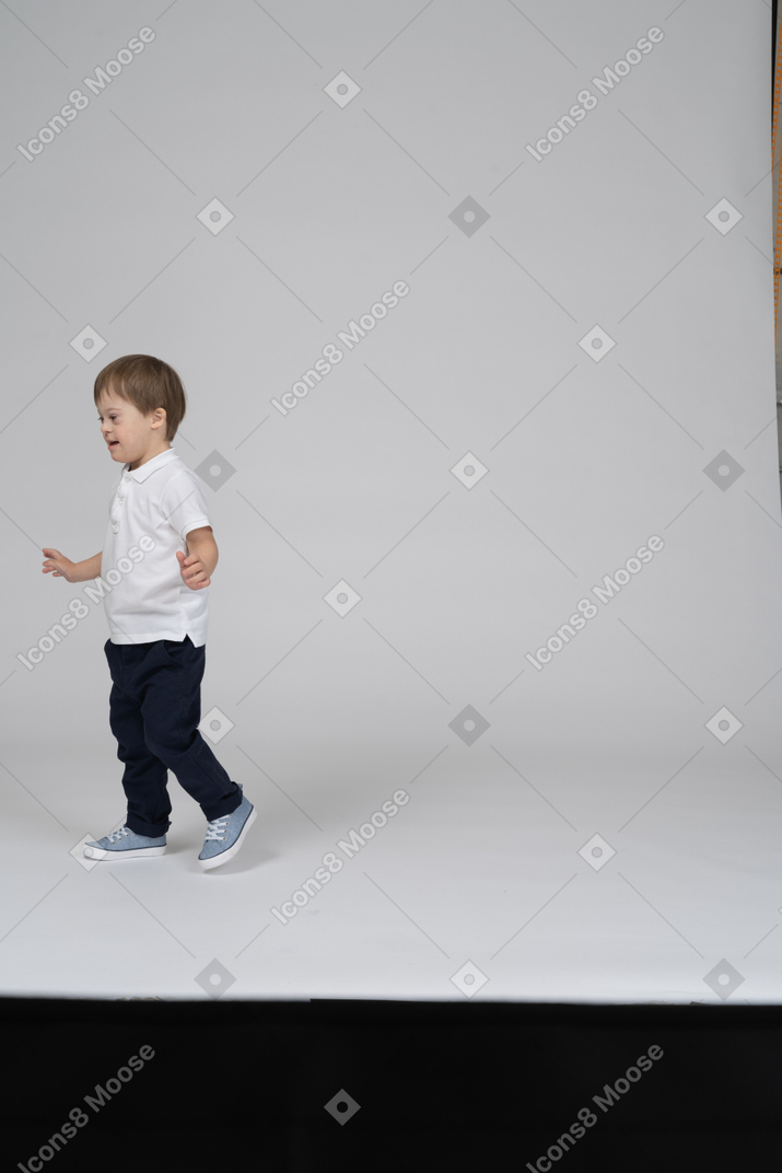 Vue latérale d'un petit garçon qui marche