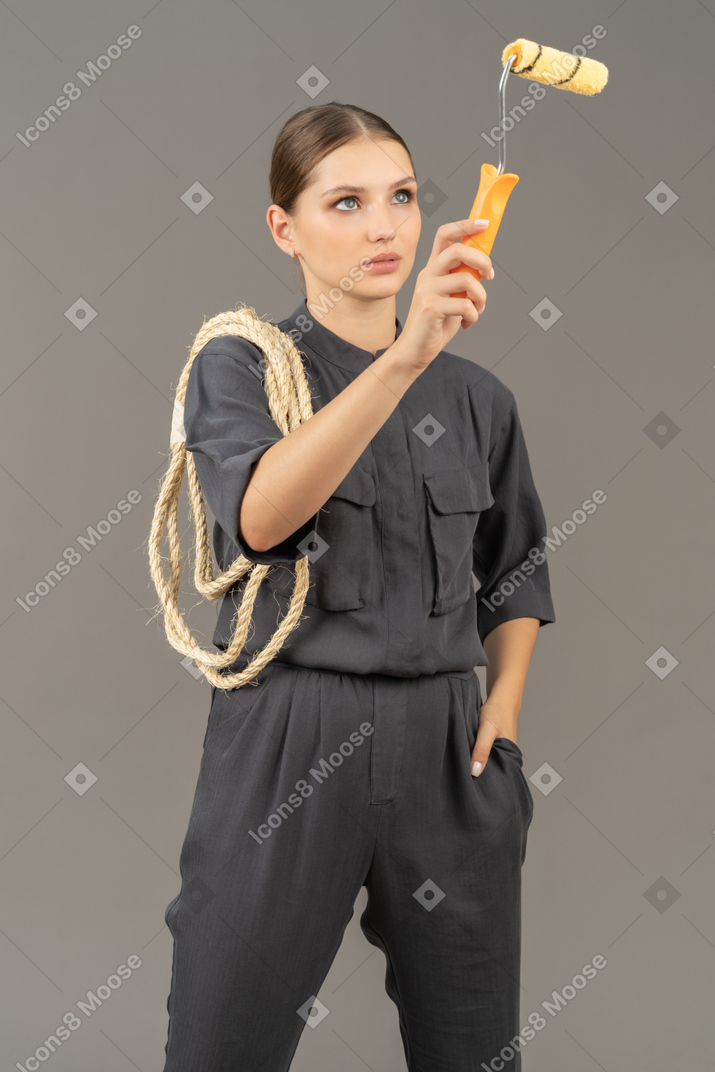 Woman in gray coveralls using a paint roller