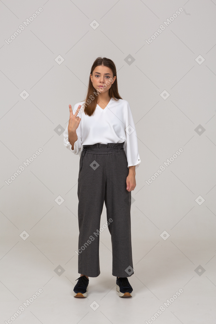 Front view of a young lady in office clothing showing two fingers