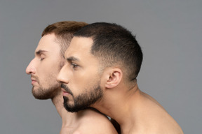 Close-up of a young caucasian man putting head on a shoulder of another man gently