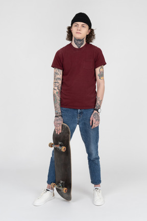 A teenager standing with his skateboard