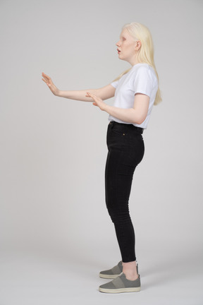 Vista laterale di una giovane donna che tiene le braccia aperte