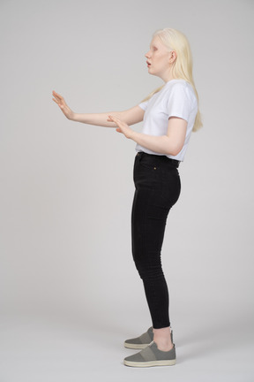 Side view of a young lady holding her arms out