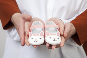 Close up of couple hands holding children shoes