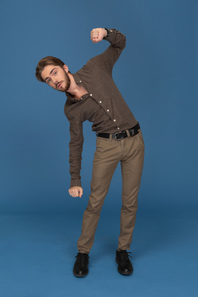 A dancing slim young man looks to camera