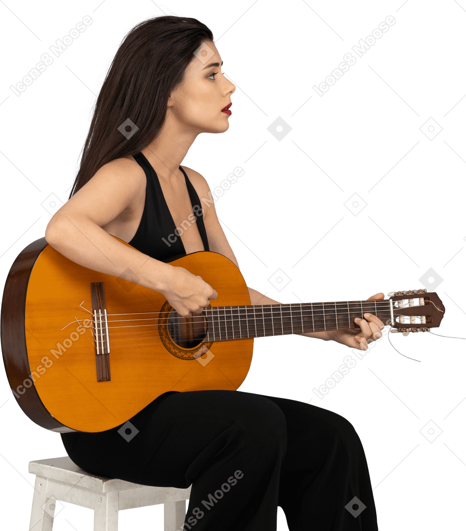Dreiviertelansicht einer sitzenden jungen dame im schwarzen anzug, die die gitarre hält und zur seite schaut