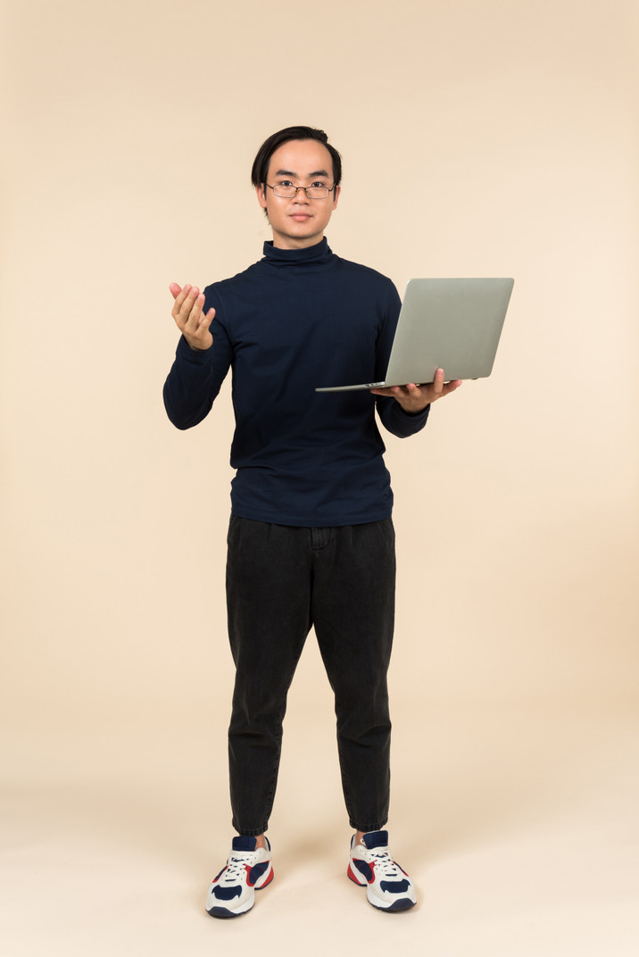 Young asian man presenting a laptop