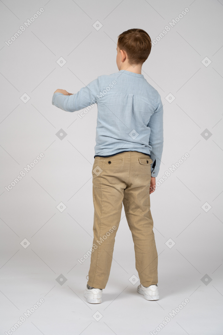 Vista traseira de um menino apontando com o dedo