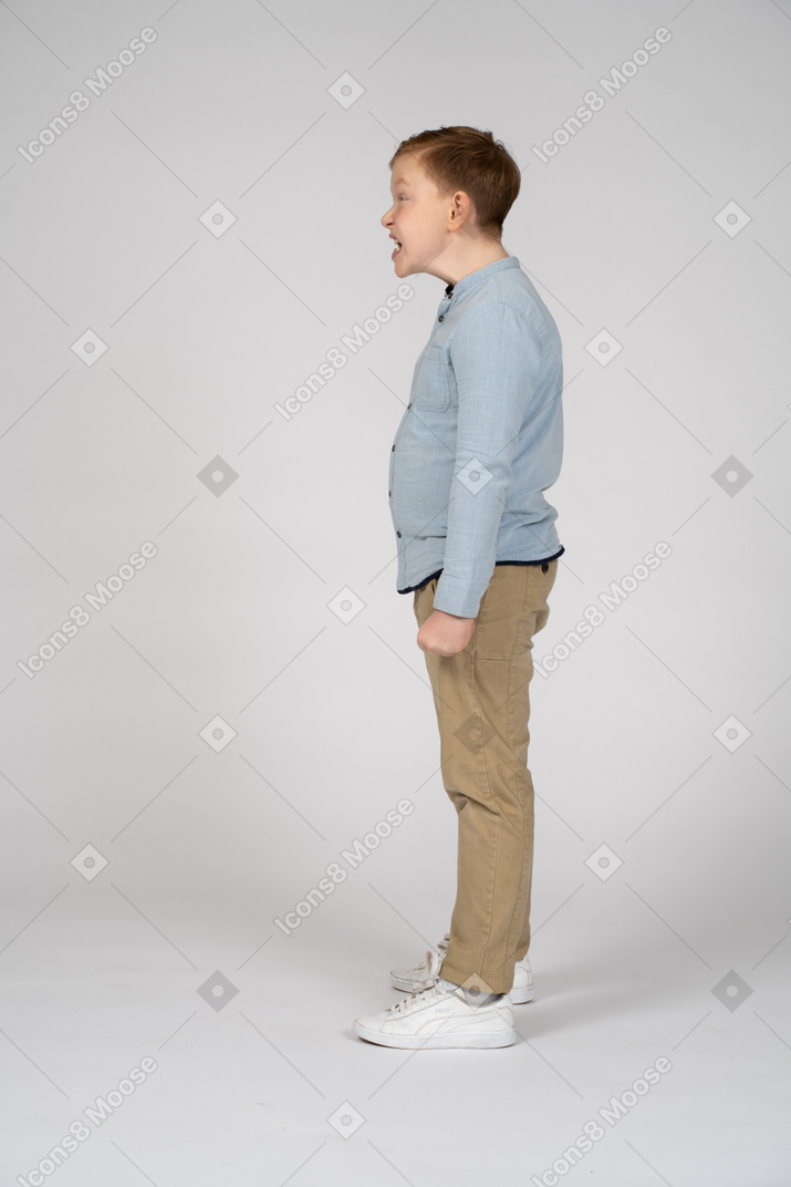 Side view of a boy making faces