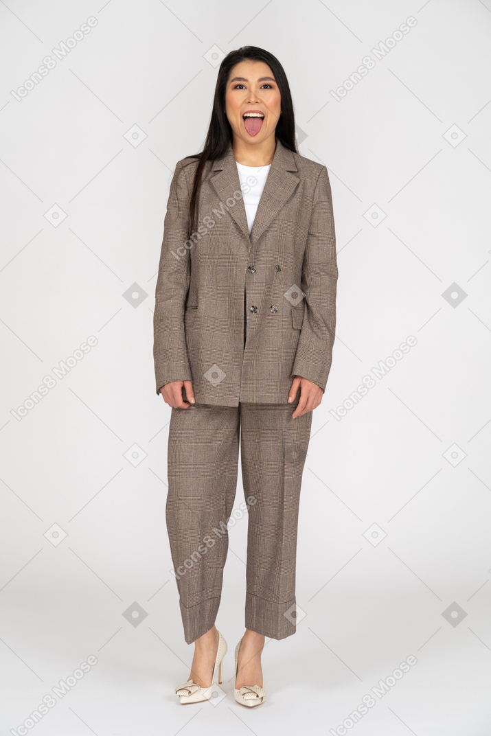 舌を示す茶色のビジネススーツの笑顔の若い女性の正面図