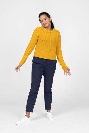 Vista frontal de uma garota com roupas casuais em pé com os braços estendidos