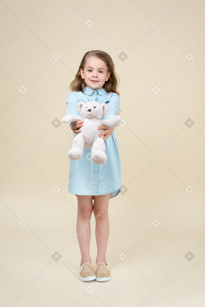 Menina bonitinha segurando um ursinho de pelúcia