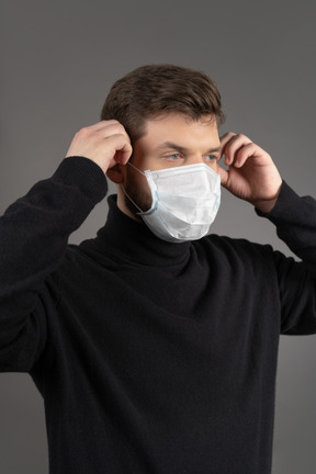 Young man wearing a respiratory protection mask during coronovirus pandemic