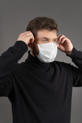 Jeune homme portant un masque de protection respiratoire pendant la pandémie de coronovirus