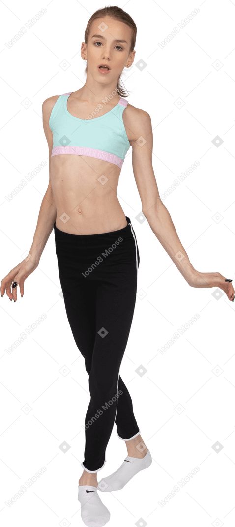Вид спереди девушки-подростка в спортивной одежде, скрестившей ноги и раскинувшей руки