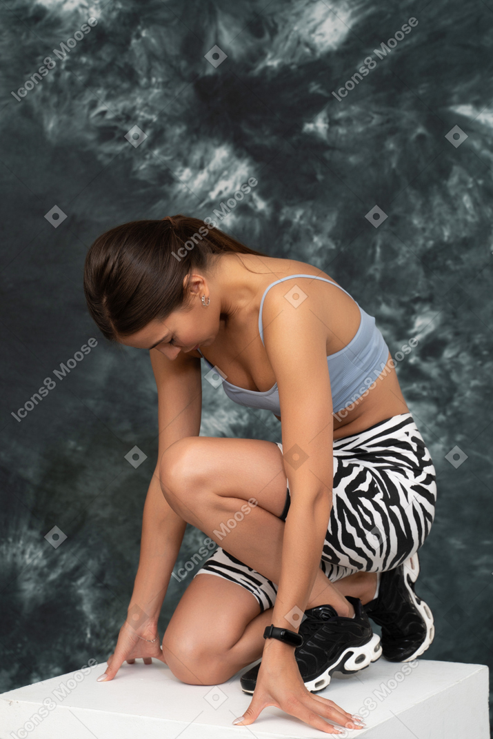 Portrait of withdrawn female athlete looking down sitting on all her fours