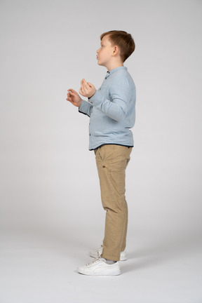 Profile of boy standing and gesturing