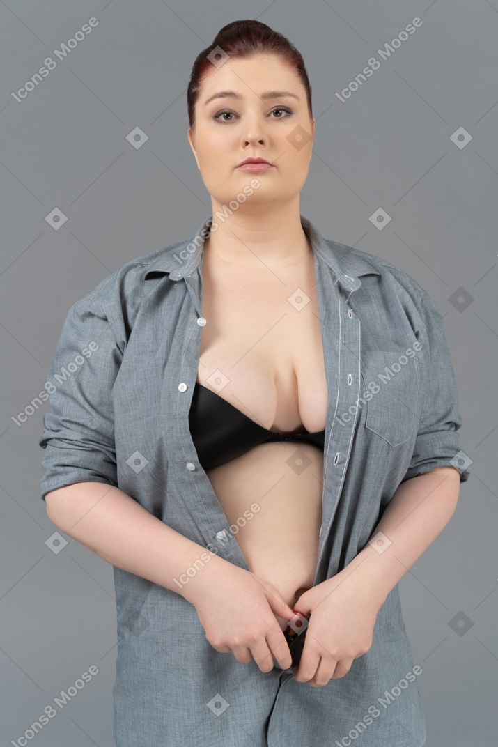 Close-up of a caucasian woman in black bra and oversize shirt