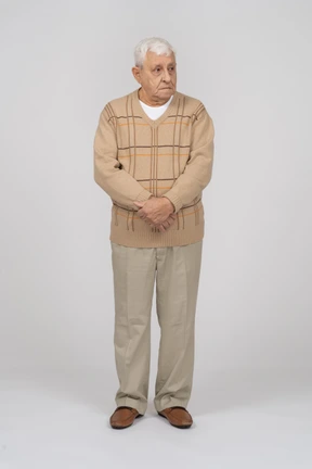 Front view of an old man in casual clothes looking aside