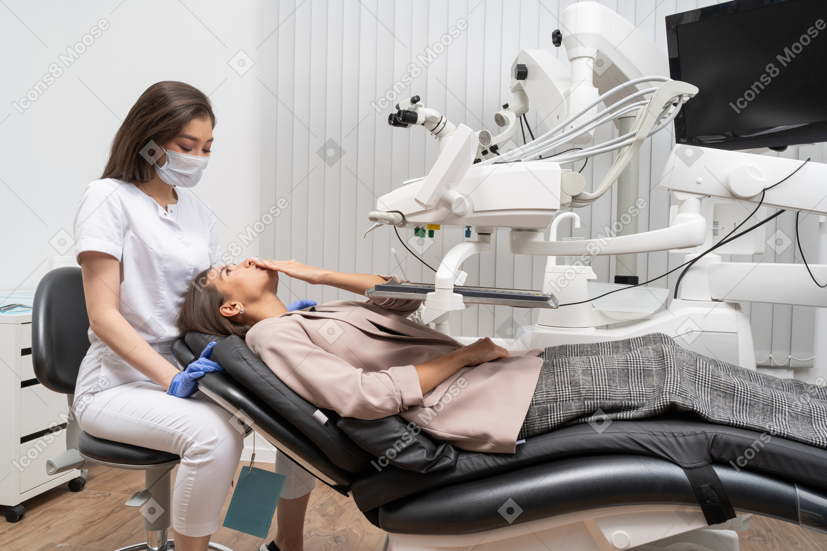 病院のキャビネットで歯科医にエアキスを送る女性患者の全身像