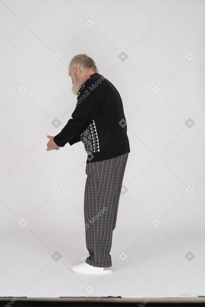 Side view of old man looking down and gesturing