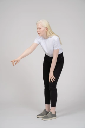 Blonde woman pointing with eyes closed