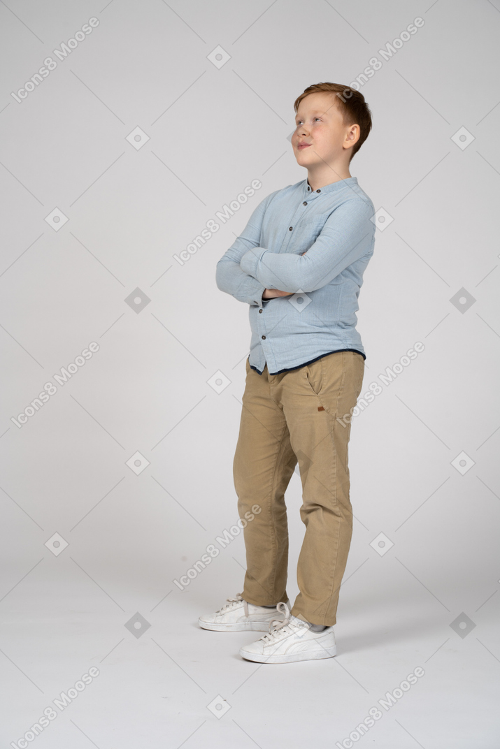 Junge posiert mit verschränkten armen und schaut nach oben