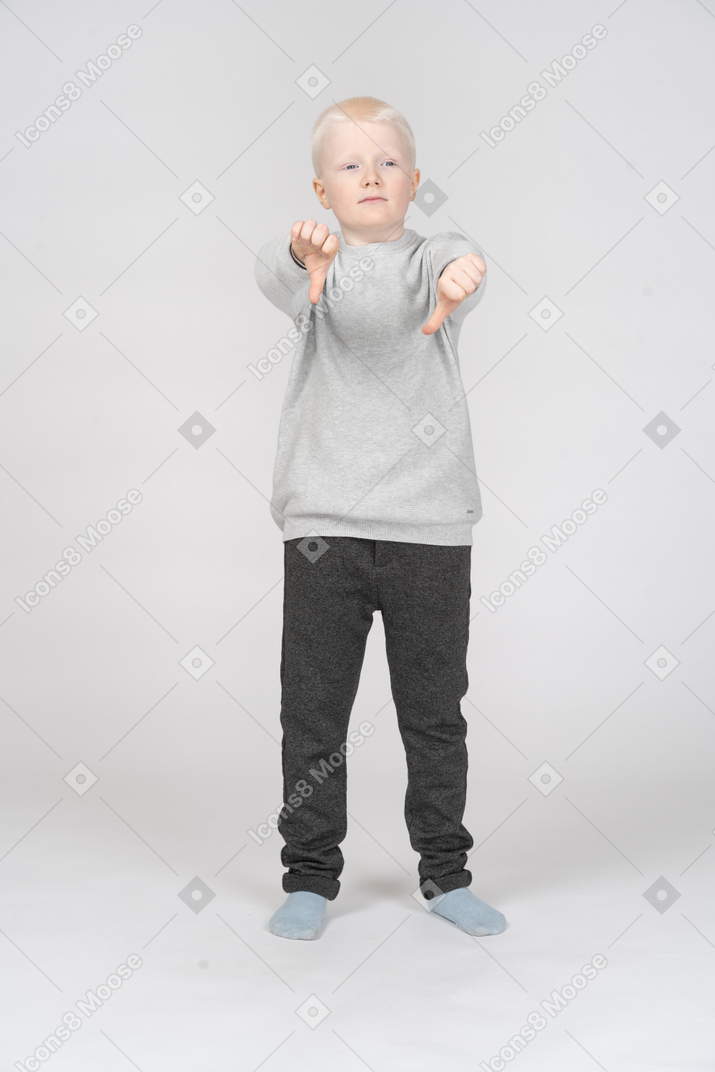 Niño pequeño mostrando los pulgares hacia abajo