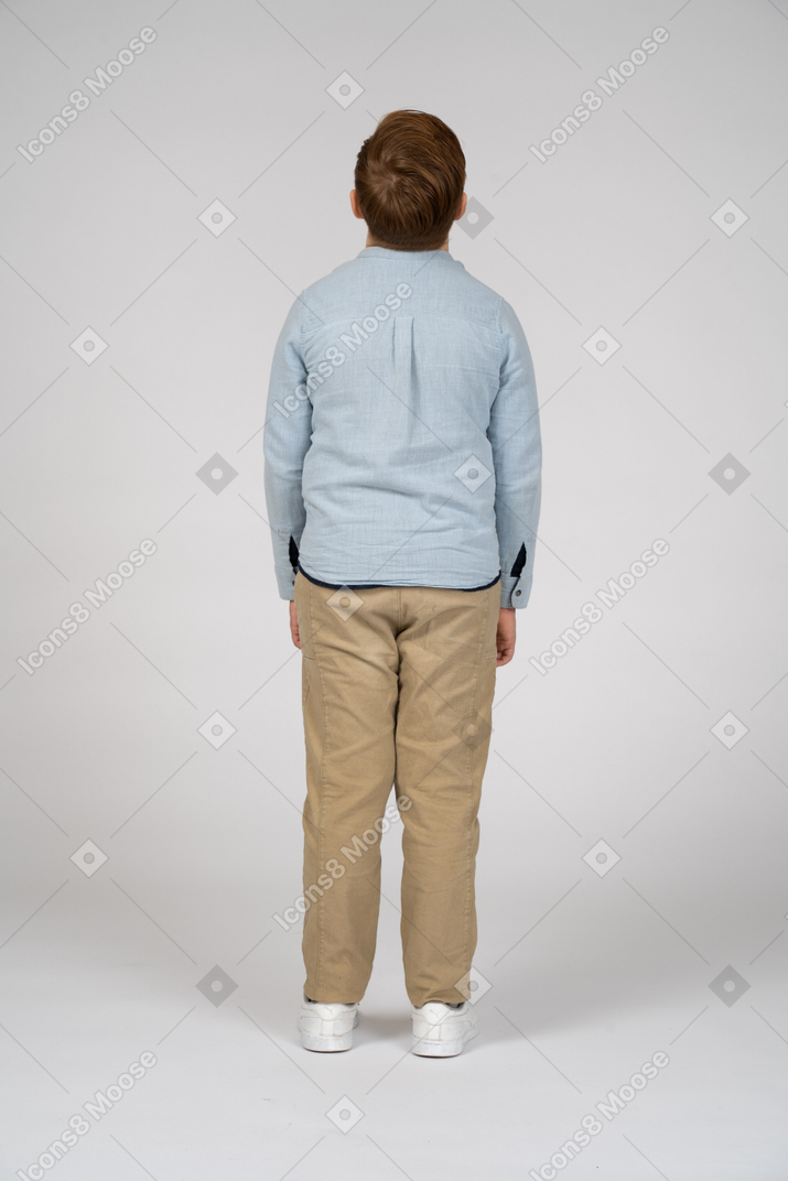 Retrovisione di un ragazzo in abiti casual che osserva in su