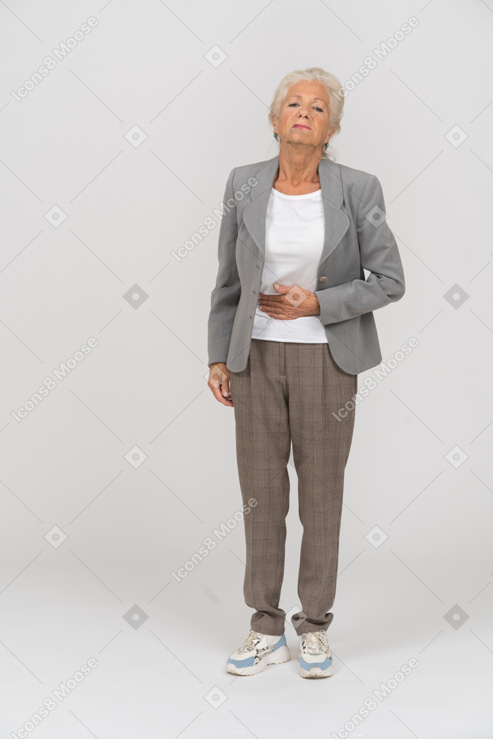 Front view of an old lady in suit suffering from stomachache