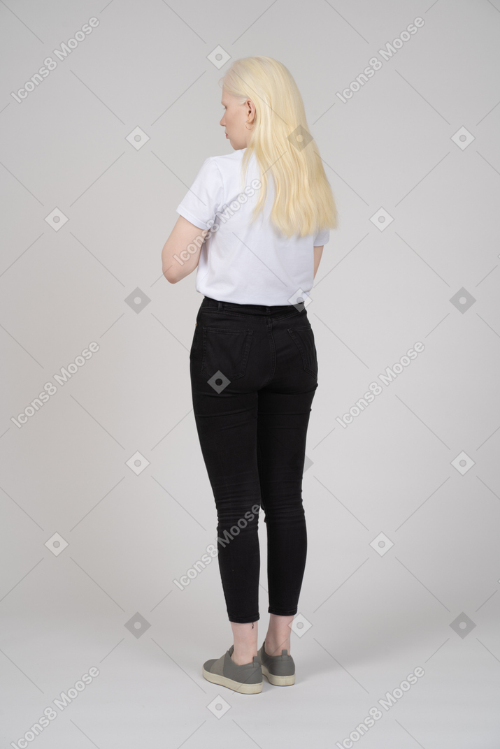 Vista traseira de três quartos de uma jovem em roupas casuais