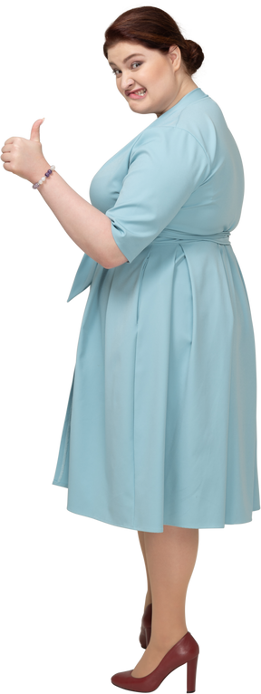親指を上に表示している青いドレスを着た女性の側面図