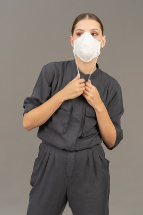 인공 호흡기를 착용하는 회색 작업복을 입은 여성