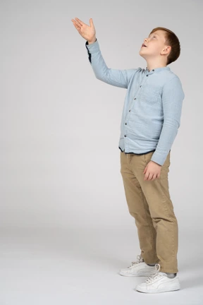 Side view of a boy pointing up with hand