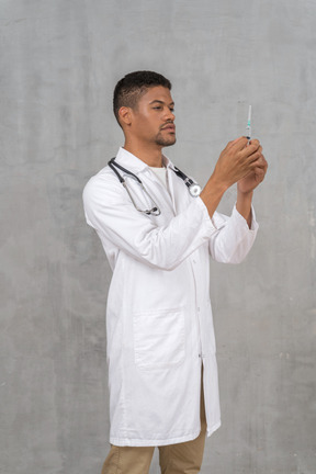 Male doctor preparing a syringe