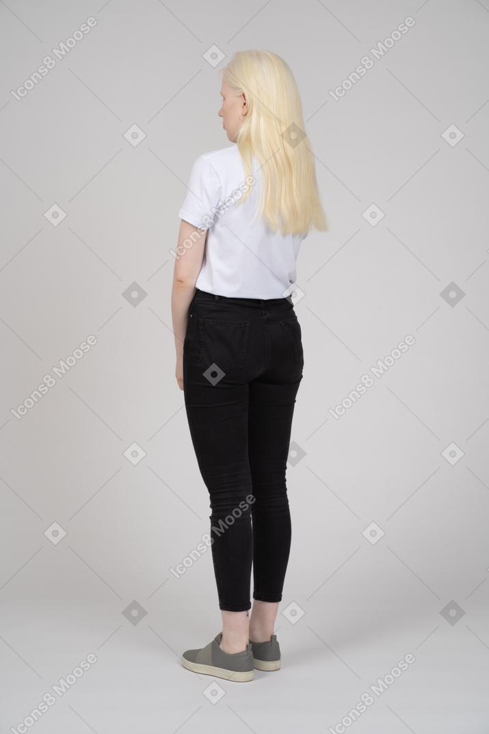Three-quarter back view of a young woman in casual clothes