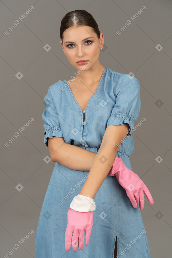 Confident young woman in latex gloves striking a pose