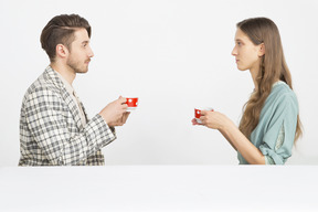 Couple having holding tea and sitting in pforile and looking at each other