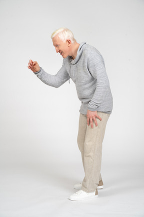 Man leaning forward and showing small size with his fingers