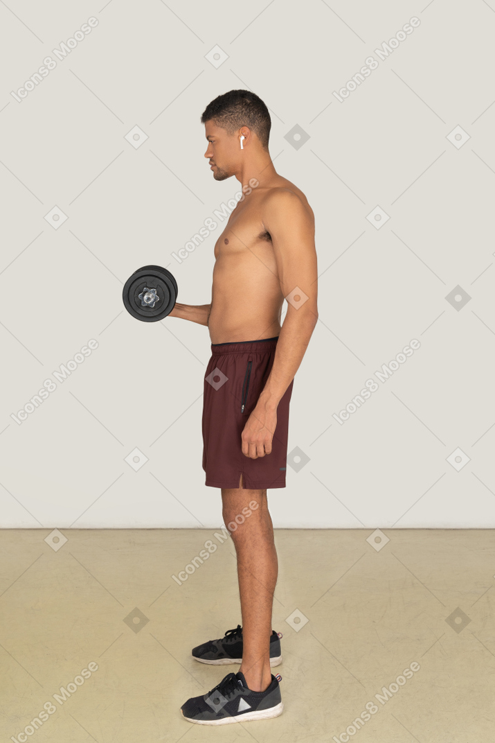 Side view of athletic man doing dumbbell exercises