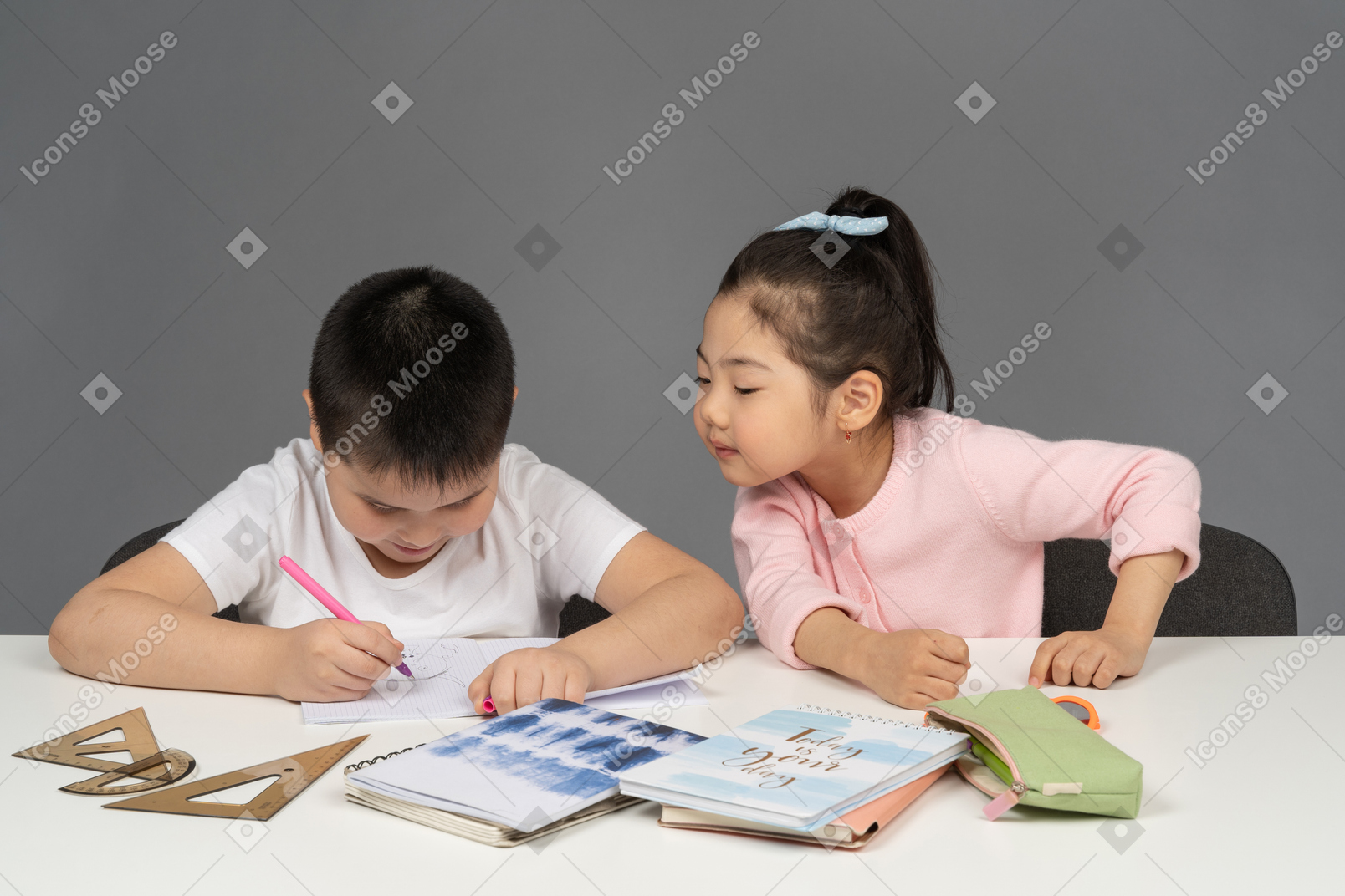 Sister watching her brother do homework