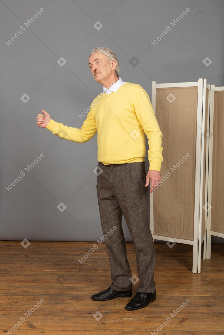 Vista laterale di un uomo anziano che mostra un pollice in su
