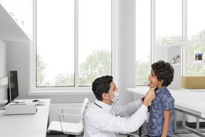 A doctor checking kid's throat