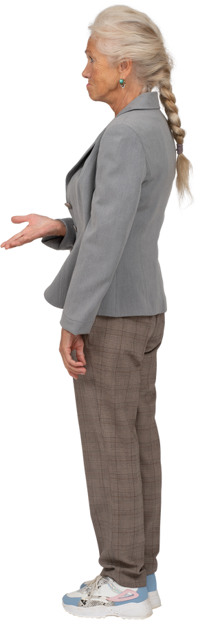 Vista lateral de una anciana en traje mostrando una mano