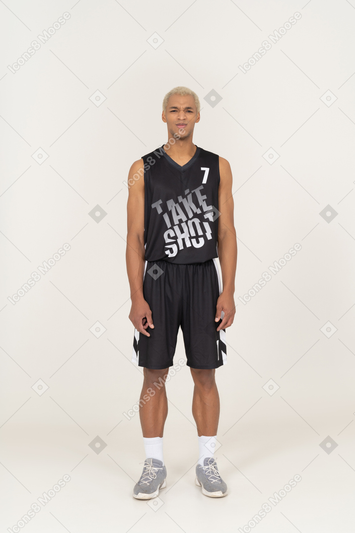 Vista frontal de un joven jugador de baloncesto masculino disgustado de pie todavía